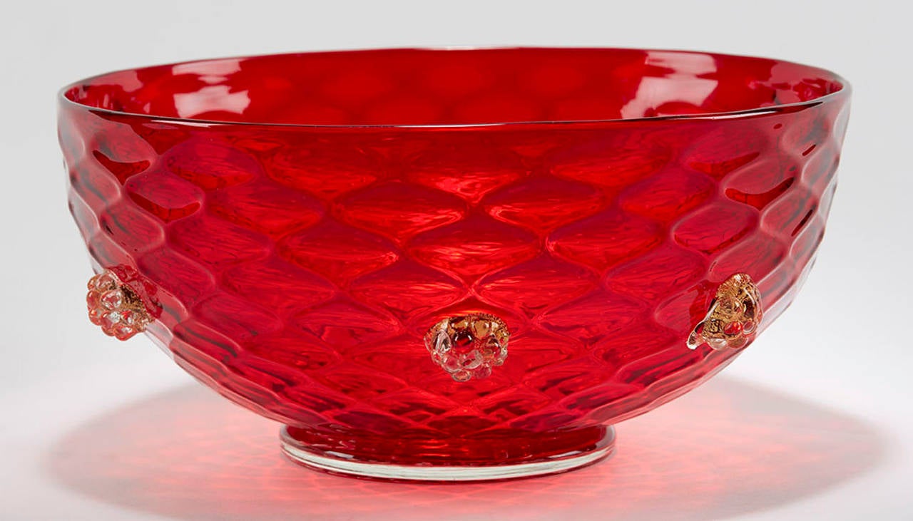 Murano hand-blown ruby red art glass rounded bowl with blackberry moulded prunts in clear glass with gold aventrine inclusions applied around the side. The bowl has a relief moulded basket-weave design with a thick clear glass rounded base applied