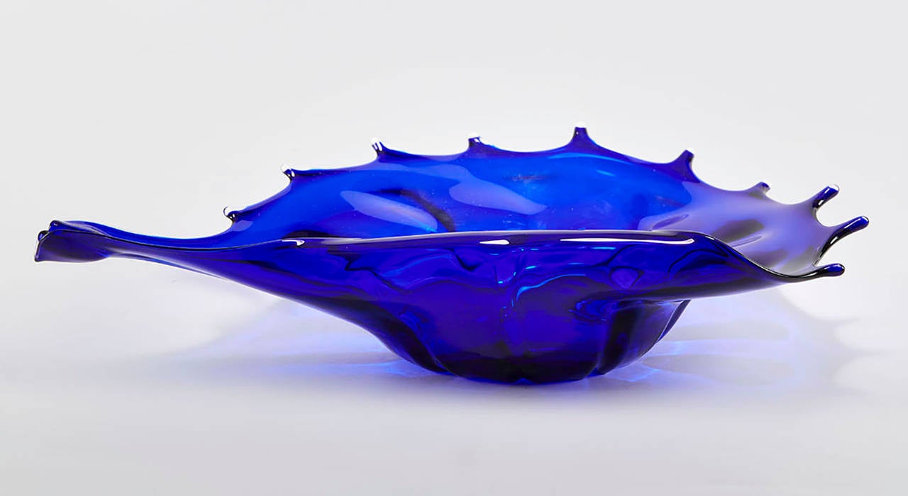 Murano handblown art glass bowl in rich blue and clear glass and modeled as a open shell standing on a narrow base with polished pontil mark. The bowl is not marked.