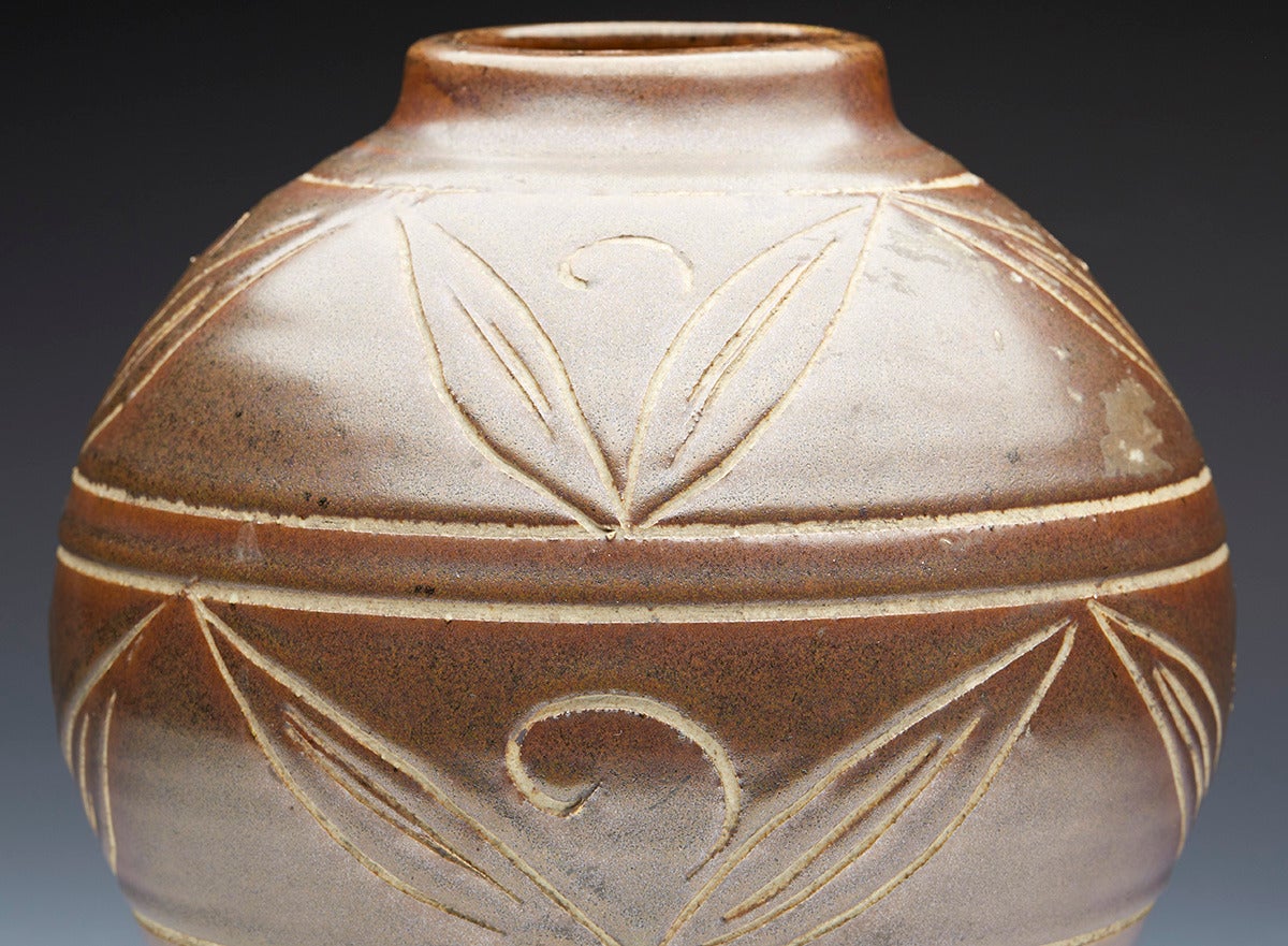 A fine vintage Poole Pottery Atlantis vase with incised groove design patterns decorated in green glazes designed by Jenny Haigh. The vase is of bulbous form with everted rim and has impressed marks to the base.