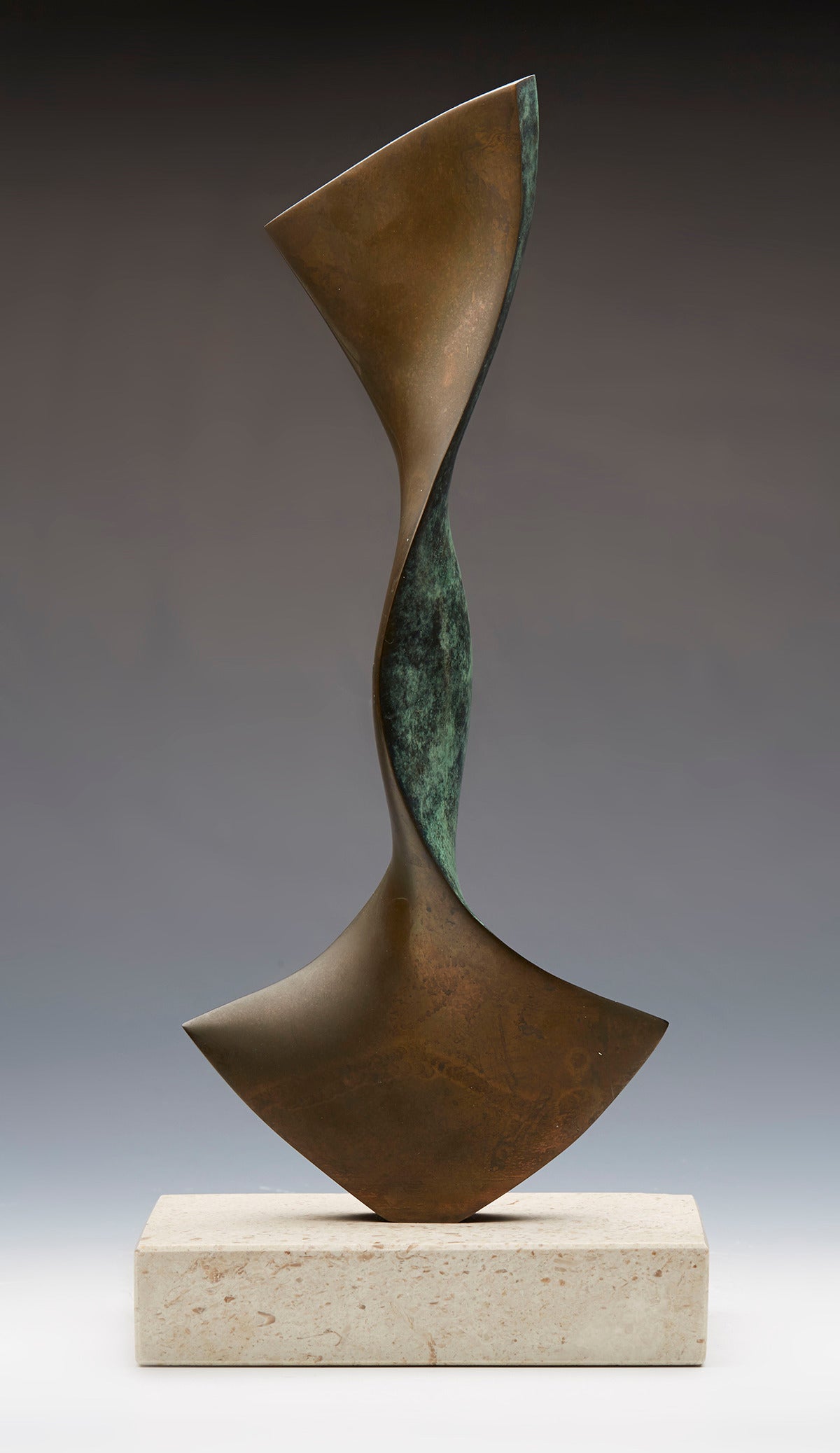 A stylish modernist bronze sculpture in the manner of Barbara Hepworth formed as a standing stylised twisted anchor design with one side applied with a green patination while the other with a polished bronze finish and mounted on a white