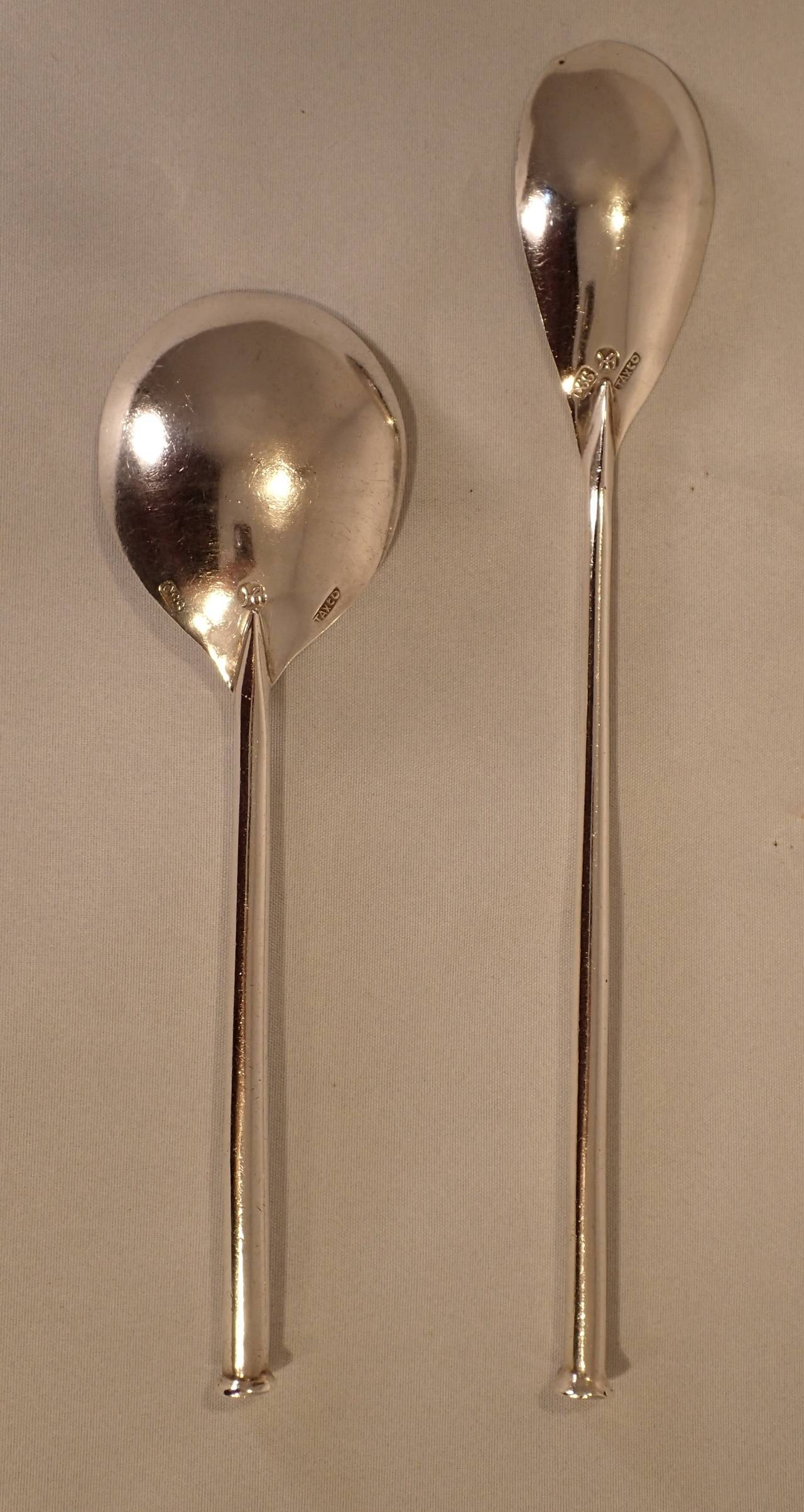 A fantastic pair of simple, slim and modern silver cocktail bar spoons by Hector Aguilar. Each formed with a nail head style handle; one culminating in an ovular martini/tea shaped bowl and the other culminating in a round juice/foam/soup/coffee