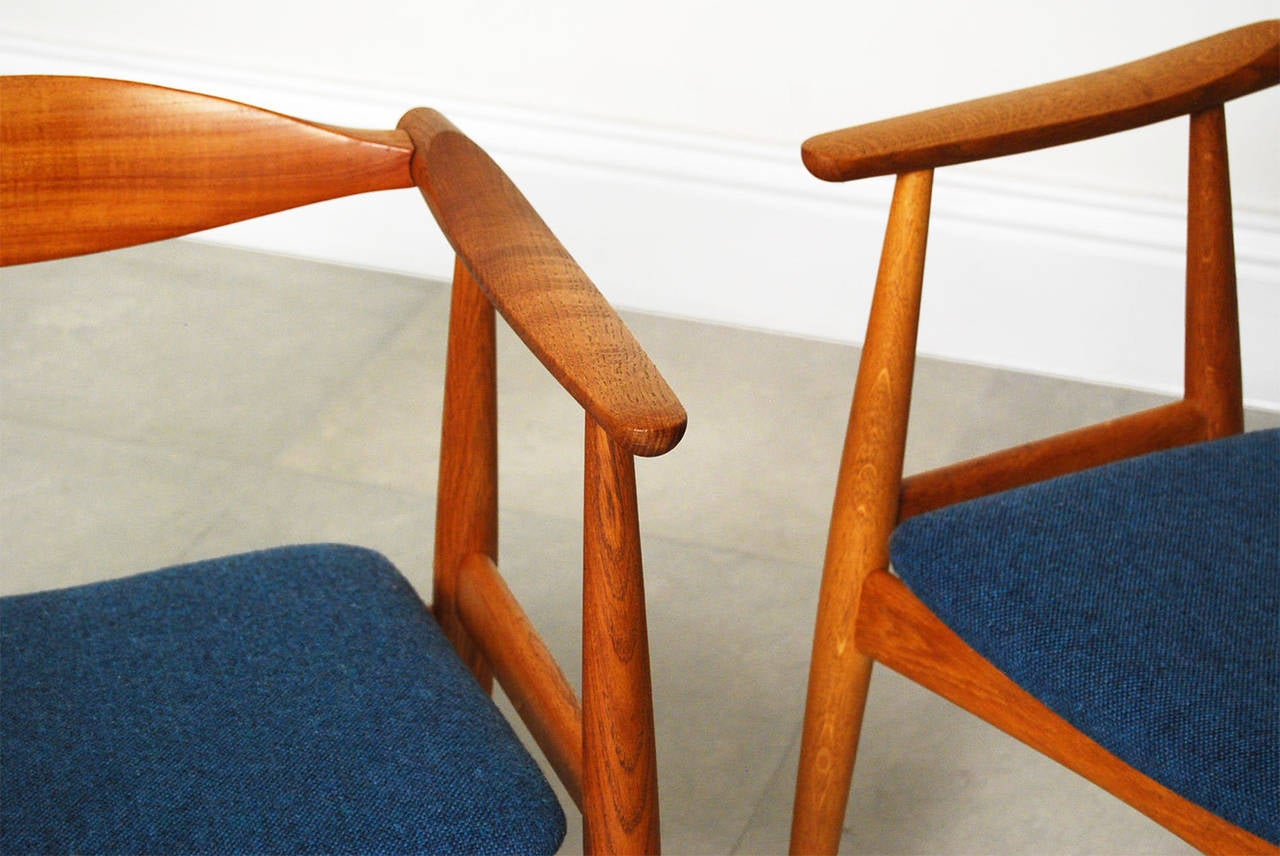 Stunning pair of armchairs designed by Hans Wegner for Carl Hansen & Son, circa 1960. The frames are made of oak with contrasting teak back supports. The seats have been recovered in a blue-green tweed from Bute.