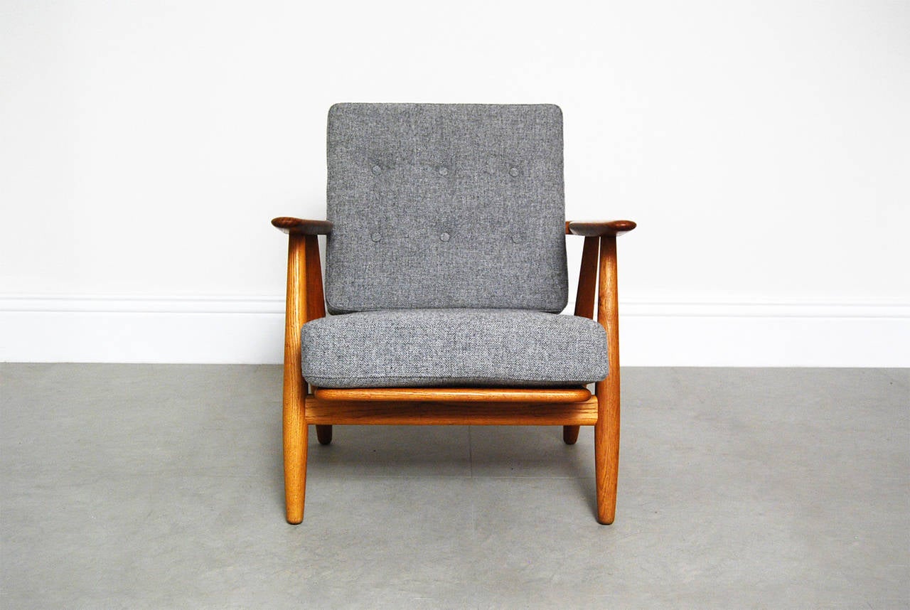 The iconic 'Cigar' chair, (model GE-240)  from Hans Wegner for Getama, Denmark, designed in 1955. This example comes with oak frame and teak armrests. The original sprung cushions have been recovered in grey Hallingdal wool fabric from Kvadrat,