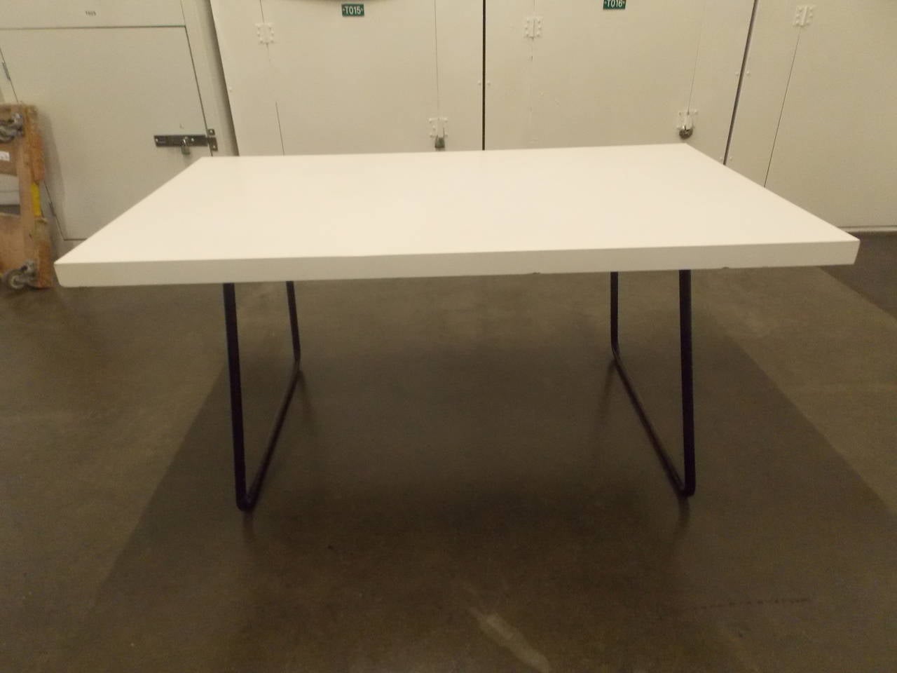 This table originally takes a glass top and still has the fittings for one.
It appears to have a custom order top that sits over the frame.
Made of plywood with white laminate.
The base frame is powder coated steel.
Great to use also as a desk.