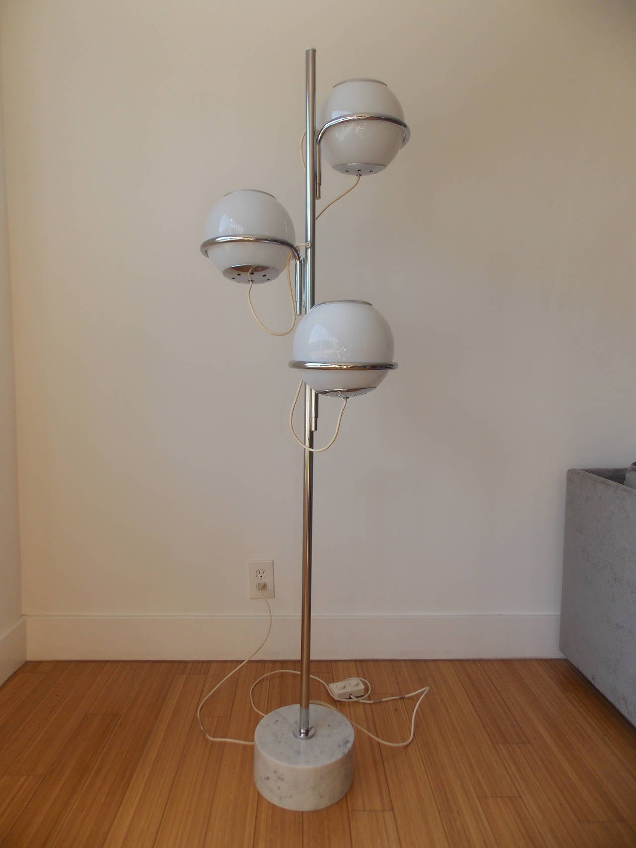 A fun design.
It's made of chrome-plated steel with three glass orb shades and heavy marble base.
It's in the original condition with original wiring.
It's sturdy and works great.