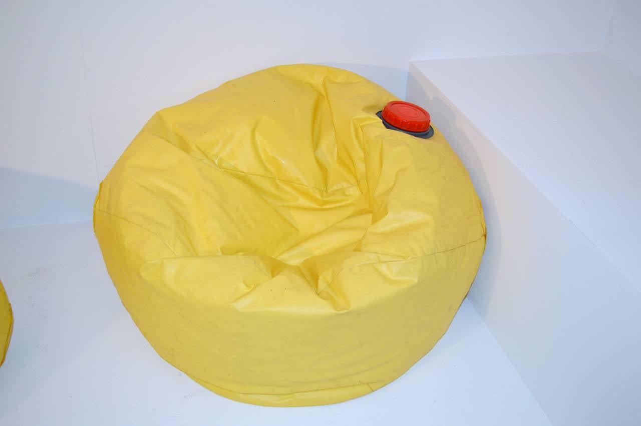 These bean bag-chairs by Ron Arad are made of yellow PVC and filled with grains of Styrofoam. They can be inflated with a pump which is included with the bags.