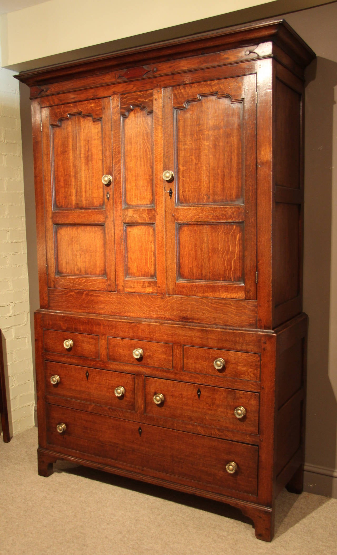 A handsome early 19th century oak livery/linen cupboard with three dummy drawers and two long. The cupboard has the original hanging pegs, also modern clothes rail. Attractive panelled construction and in excellent order, circa 1820. 

All of the