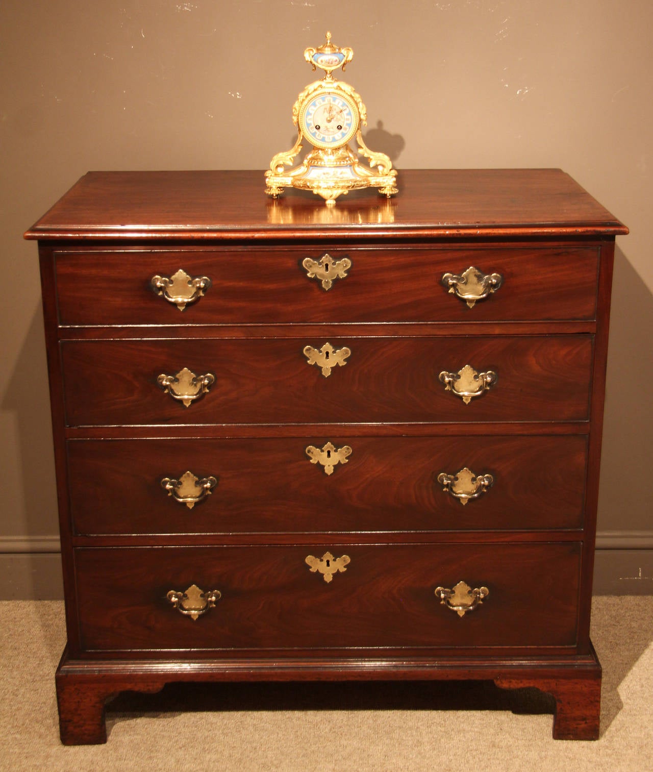 George II mahogany chest of drawers on original bracket feet. Replaced handles and escutcheons, circa 1790. 

Shown with a beautiful French porcelain mounted ormolu mantel clock, circa 1875 £2875. 

All of the items that we advertise for sale