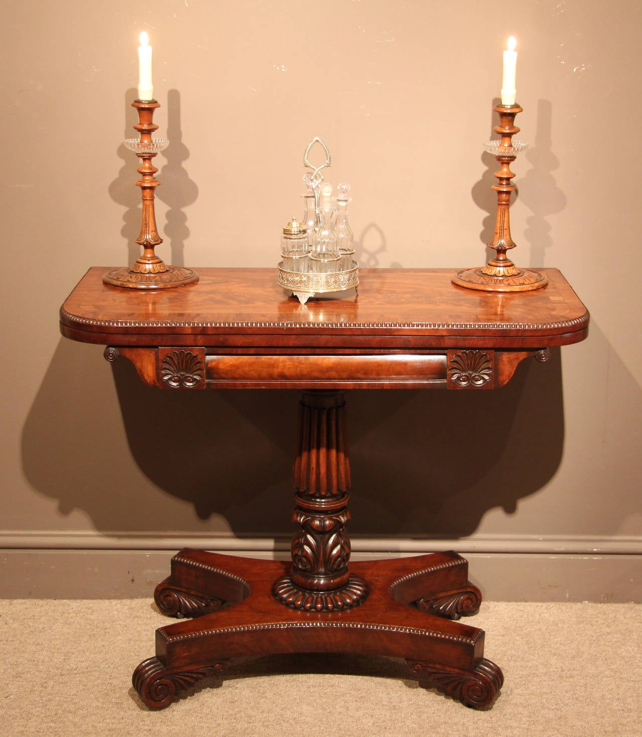 A superb late Regency mahogany card table with carved shell motifs and reel decorated edges in quadraform base with baize-lined interior surface, circa 1815. 

All of the items that we advertise for sale have been as accurately described as