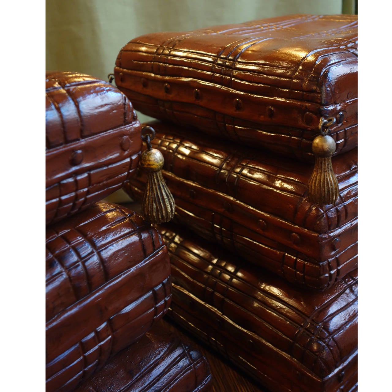 Pair of 20th century Italian wooden stools in the shape of stacked pillows. Reddish brown lacquer finish with carved tassels.
