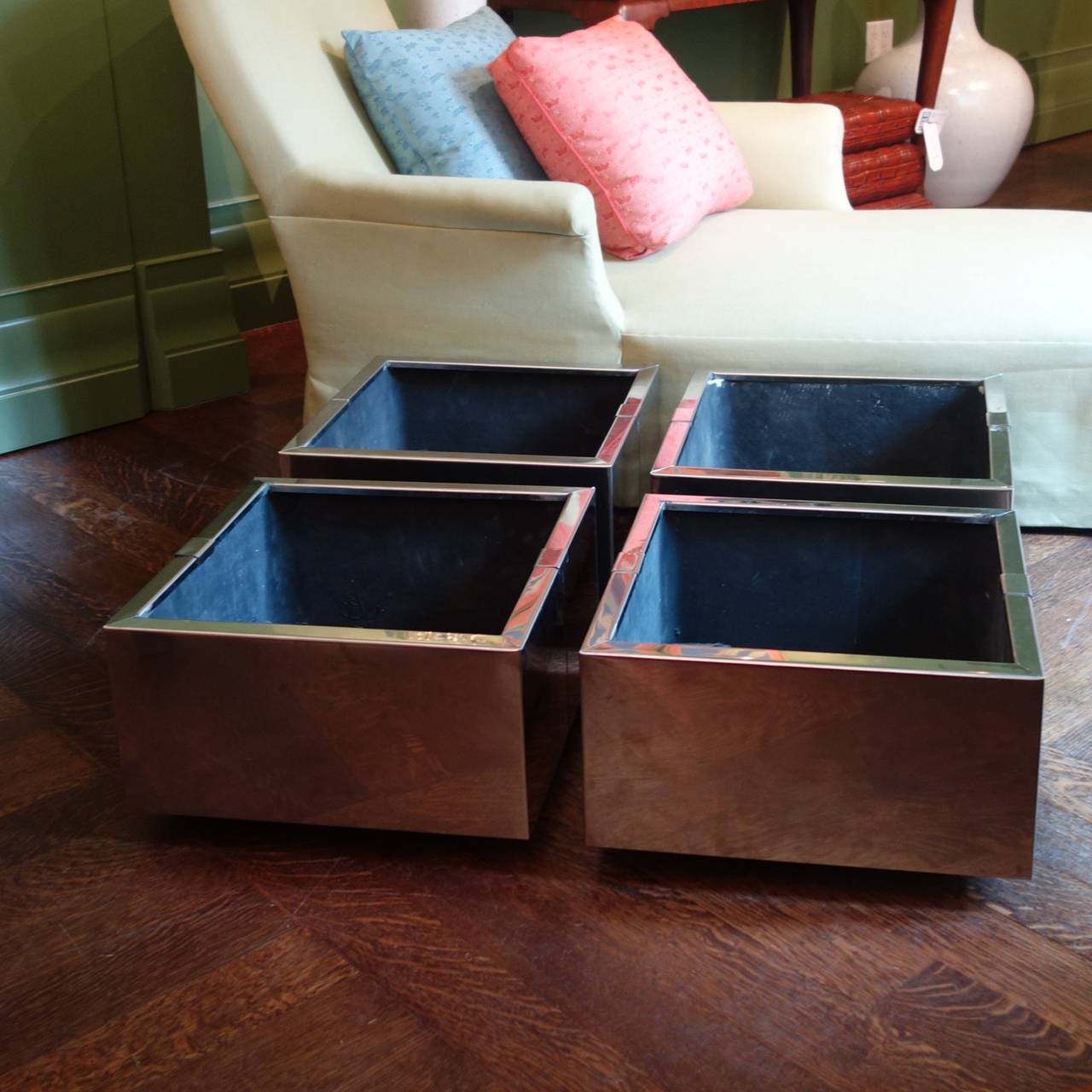 Set of four French 1970s chrome planters. Chrome frames cover solid cast body which sit on small inset feet for an overall cantilever effect. Sleek profile with cap detail.