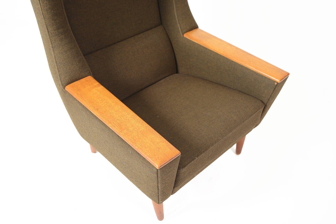 This gorgeous wingback lounge chair offers classic Danish modern design perfect for any room in need of a stunning focal point. The large winged head rest provides comfort as well as a striking silhouette. The armrests feature quarter sawn oak paws.