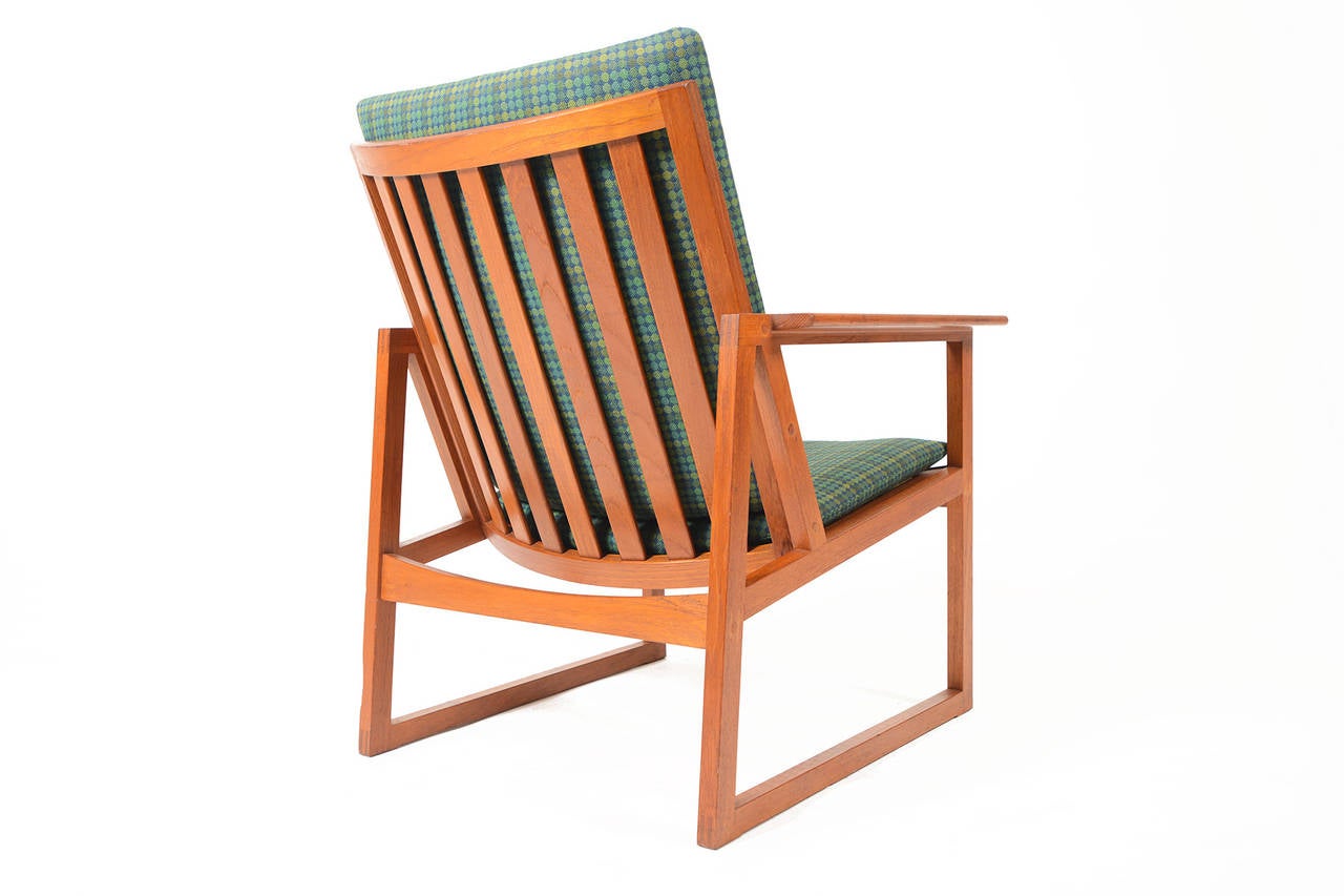 This pair of Danish modern mid century teak lounge chairs was designed by Børge Mogensen for Søborg Møbelfabrik. The frames feature gorgeous finger-joinery and arched backrests. Chairs wear an emerald and cobalt patterned wool blend. In excellent