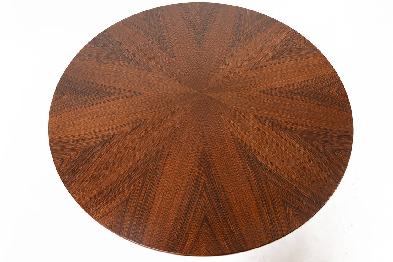 This Danish modern mid century circular coffee table in Brazilian rosewood features a starburst veneer inlay and tapered legs. A perfect coffee table or side table for any modern home. Recently refinished and in excellent condition.