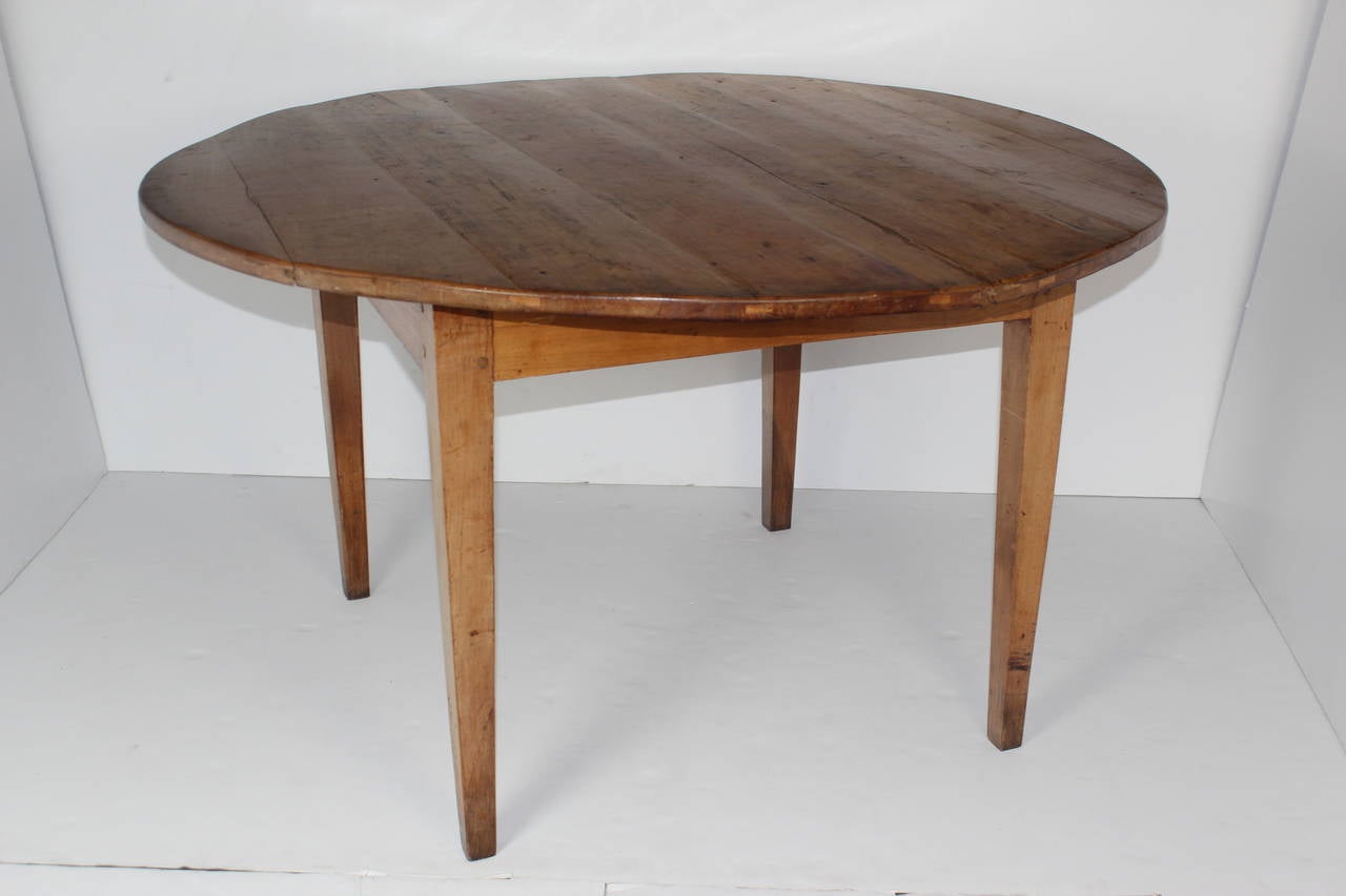 19th century fruitwood French Provincial round table with four tapered legs. 