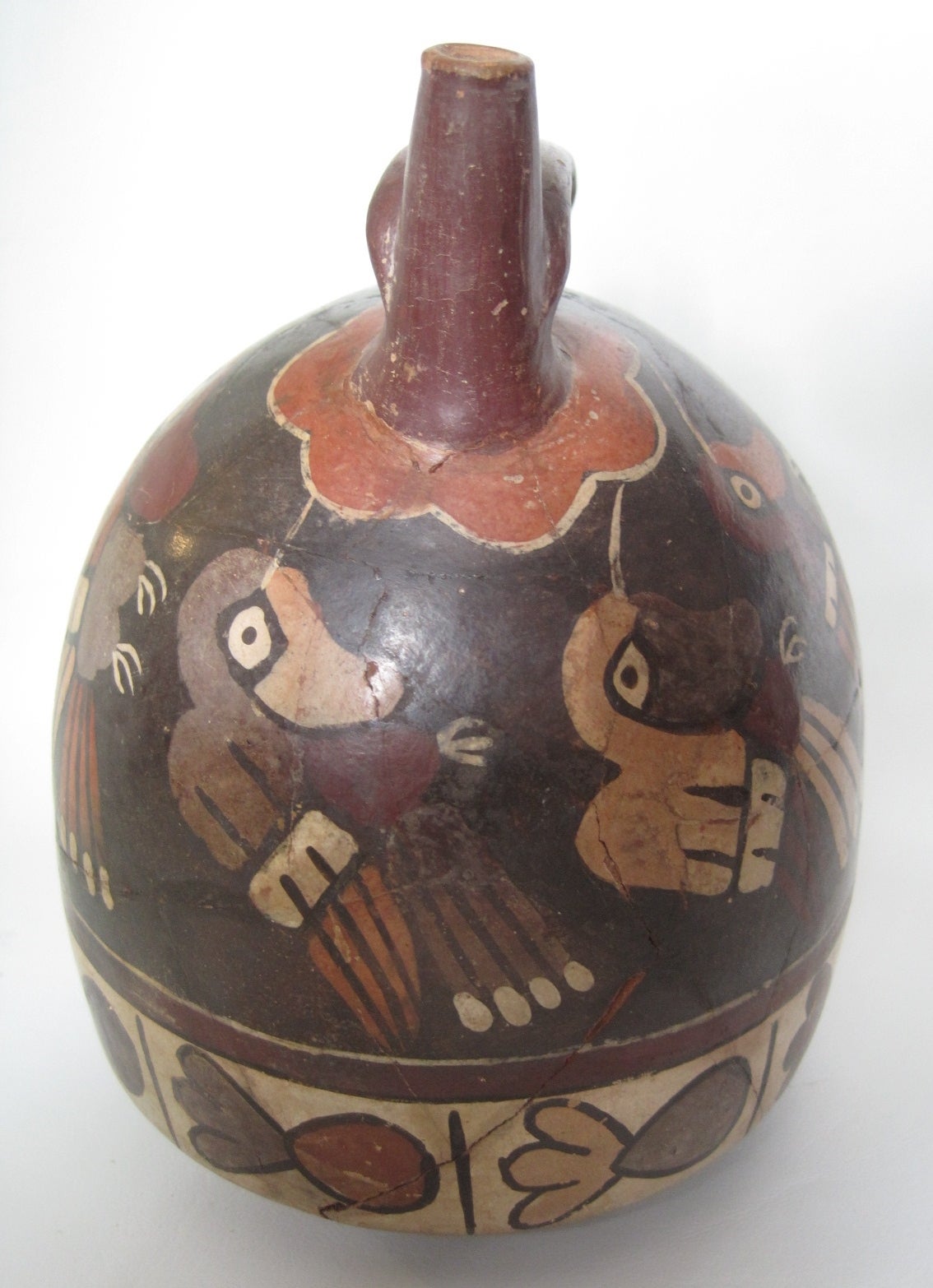 Pre-Columbian Nazca Polychromed pottery vessel, circa 100 B.C.

Double spout and bridge pottery vessel. The exterior is painted in red, orange, light pink, grey, crimson, white and brown, and depict a repeating motif of a multicolored bird with