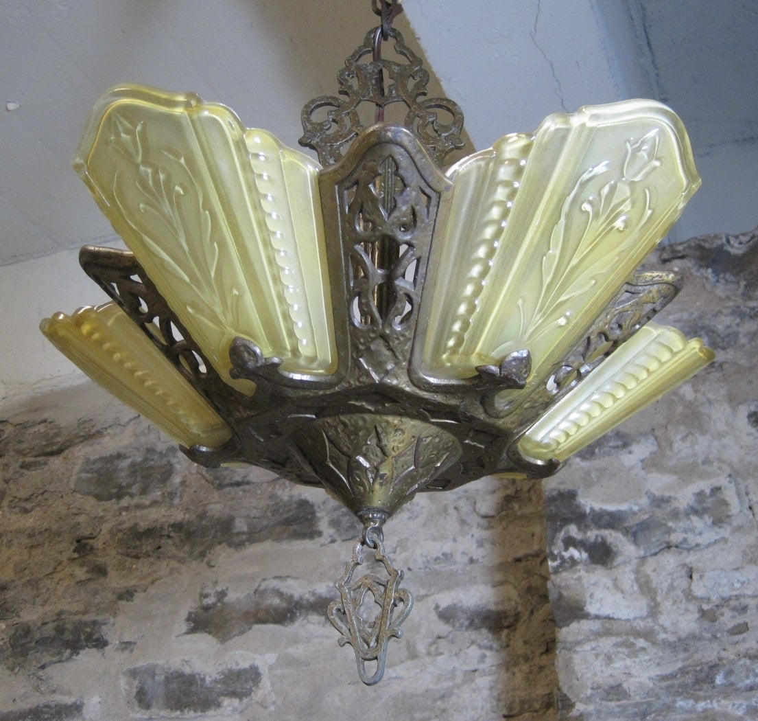 Art Deco slip shade chandelier light.

This charming Art Deco chandelier was made circa 1920. It has five original amber glass slip shades. The metal work still maintains its warm bronze colored patina.

Free shipping within the United States