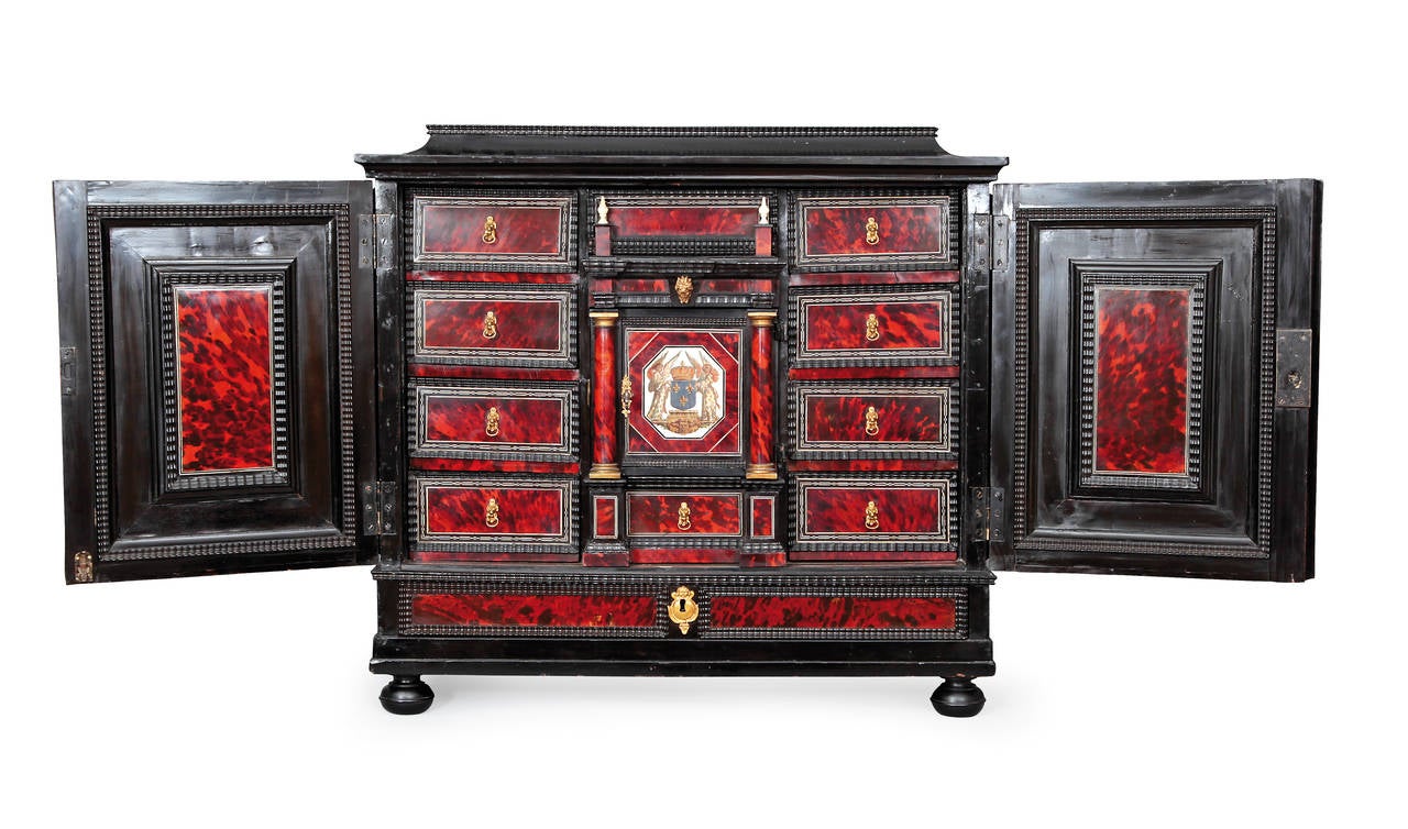 Made of ebony and écaille, decorated with painted scenes on ivory. The cabinet opens in facade by two leaves with panels of ivory decorated with paintings in the taste of Jacques Callot. In the lower part, a drawer veneered in écaille. The side of