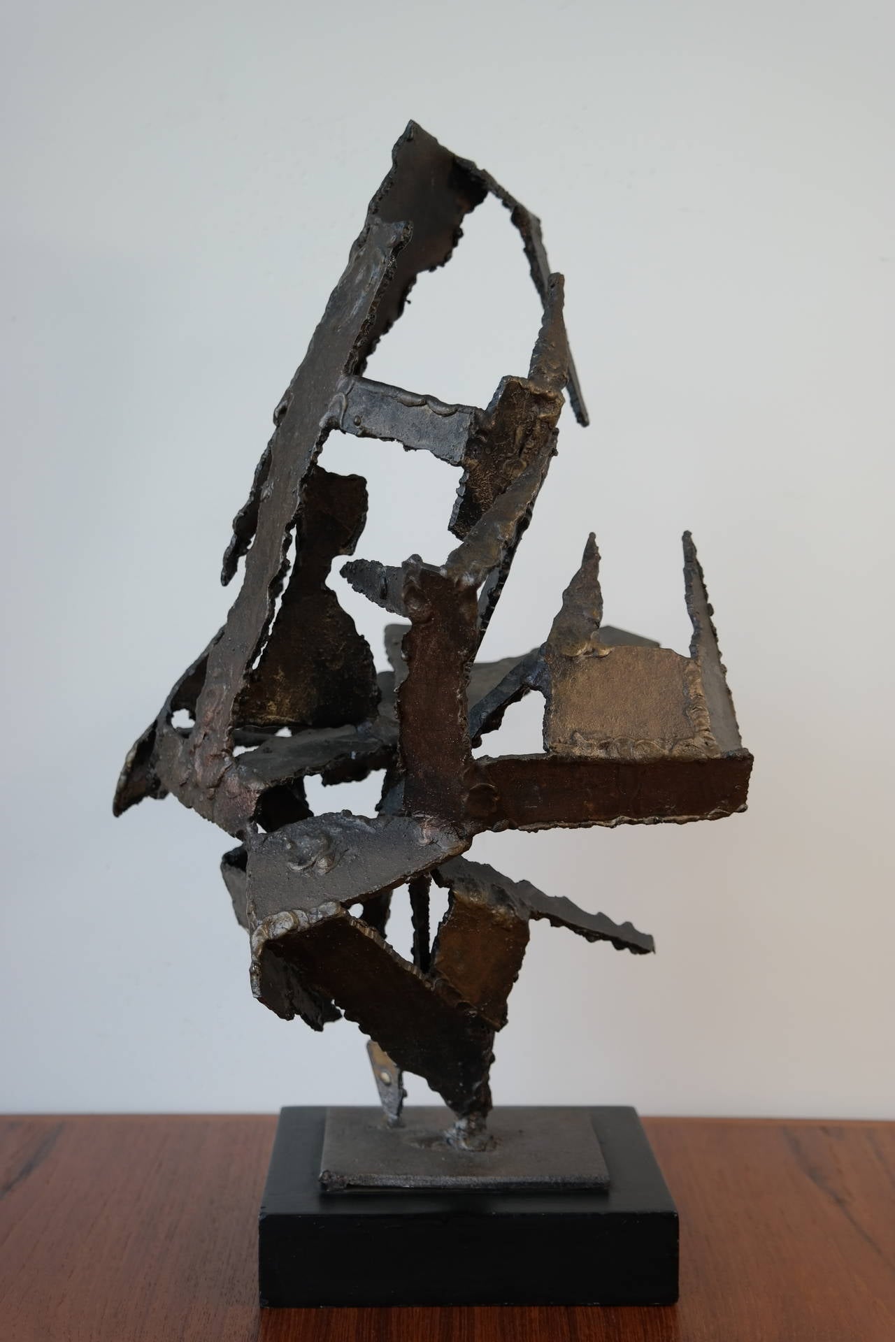 Impressive brutal sculpture mounted on an ebonized wood base. A very decorative piece of art that goes well in any décor, made of individual torch cut pieces of metal welded together to make this impressive sculpture. Shows some signs of wear with