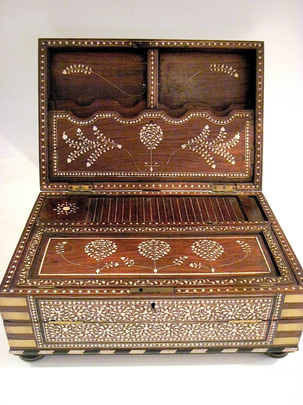 Elegant and finely crafted rosewood and ivory inlay traveller's writing desk from the late Mughal period of British India (circa 1825), on low bun feet. In excellent condition, with no missing inlay or damage. The exterior is lavishly inlaid on the
