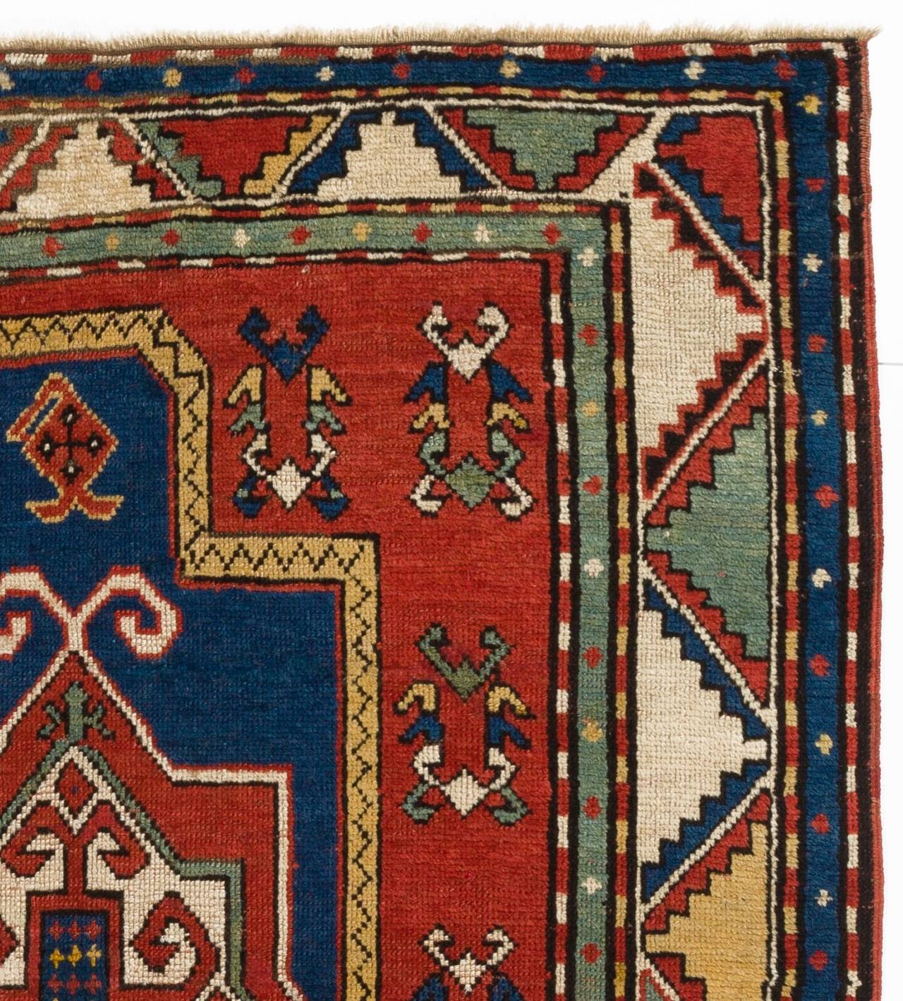 An outstanding Kazak prayer rug with glowing natural colors and a well-balanced geometric design including a madder red and ivory shield on an indigo niche framed with a colorful zig zag border and alternating mint green and indigo blue secondary