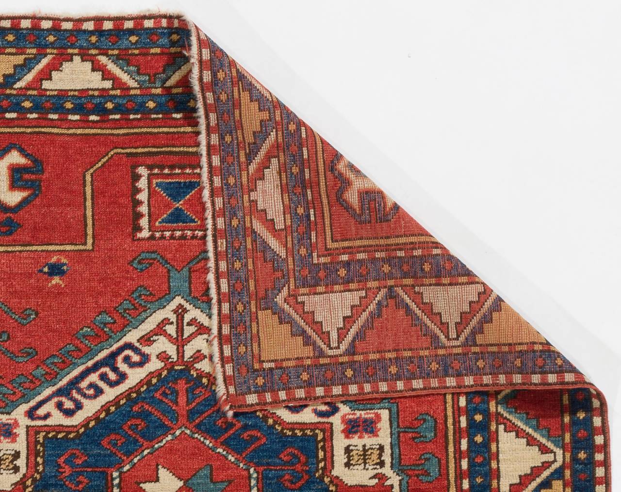 An old hand-knotted Caucasian Kazak rug with a bold and geometric design and splendid natural dyes. Wool pile on wool foundation, very good original condition.