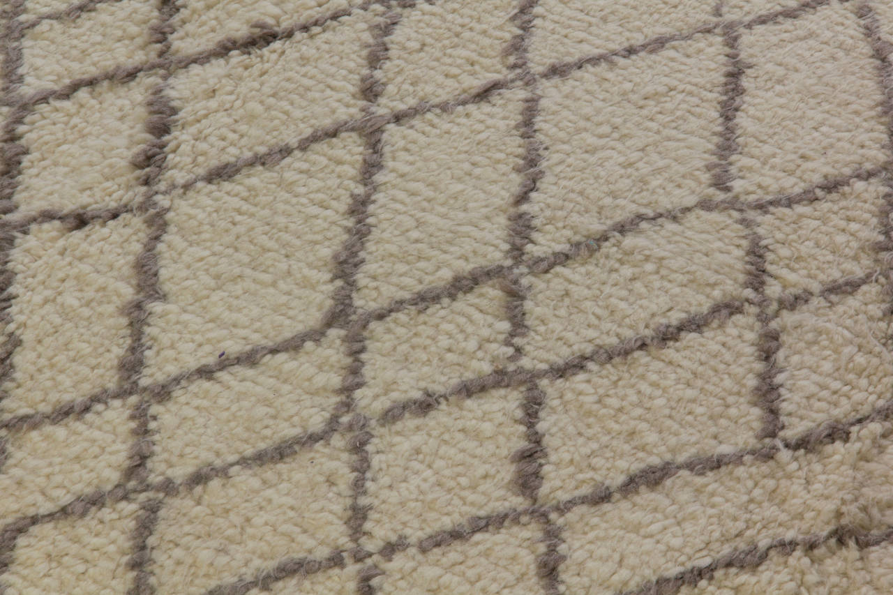 A modern handmade rug made of natural un-dyed ivory and light gray sheep wool. The design is inspired from vintage Moroccan rugs. 
The rug is available as seen or it can be custom produced in a different size, colour combination and design.