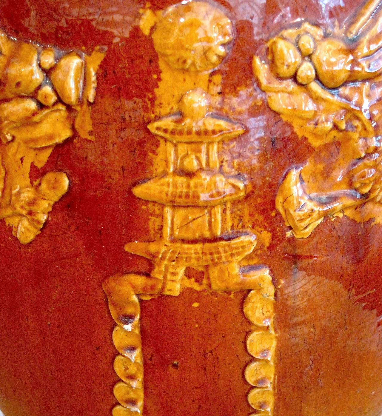 This monumental Korean kimchi (spicy fermented cabbage) storage jar truly has an impressive, almost regal presence. It is made of heavy, clear glazed terra cotta and has applied decoration in the form of two large dragons facing a temple, with hand