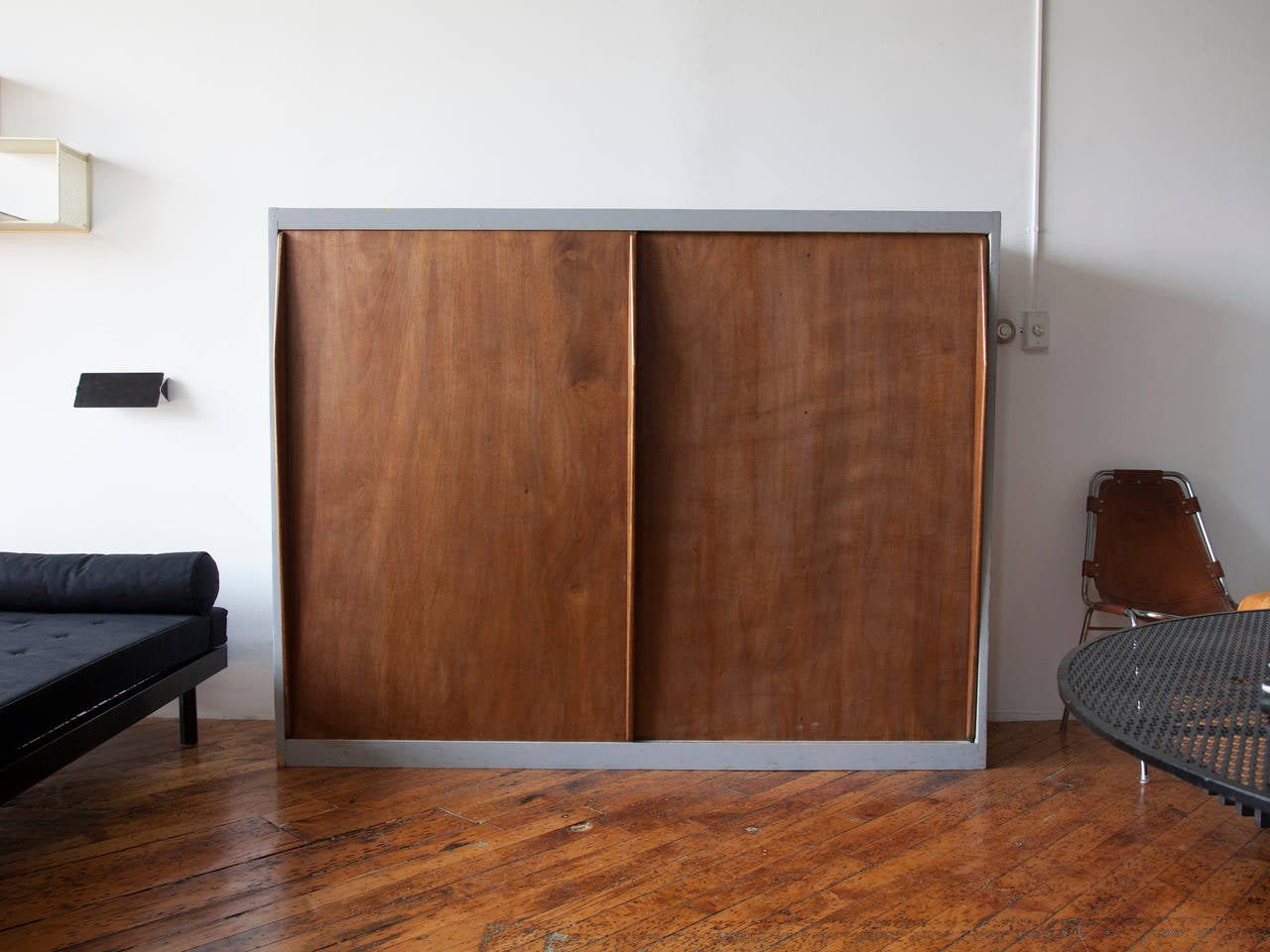 Double-sided room divider with sliding doors and carved handles from the Unité d'habitation, Marseille, by Le Corbusier. Opposite side of divider has small storage compartment for books at bed height.