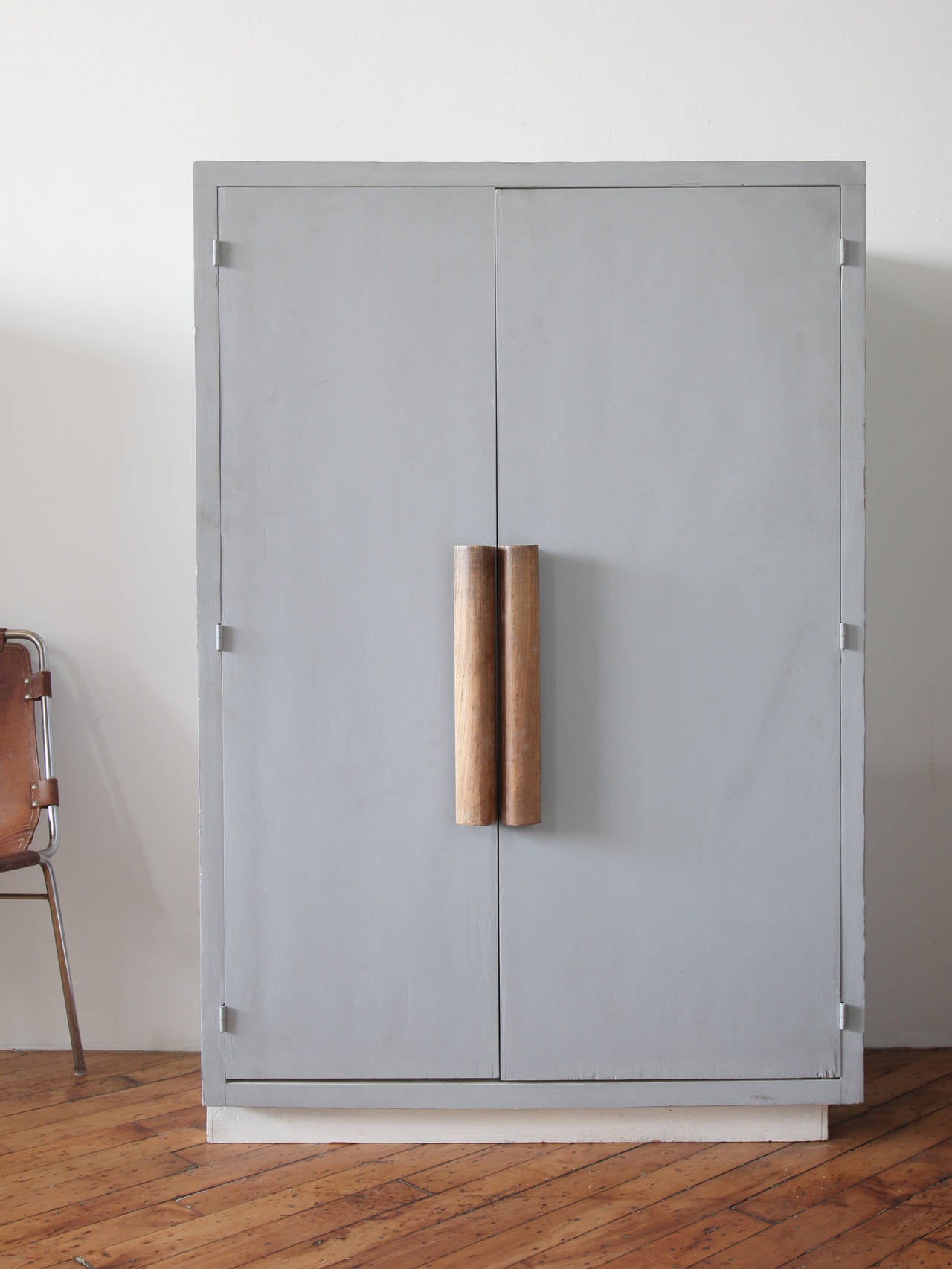 Armoire with carved wood handles and asymmetrical base meant for corner placement designed by Swiss architect Le Corbusier for a student room in his Unité d'habitation, Marseille.
