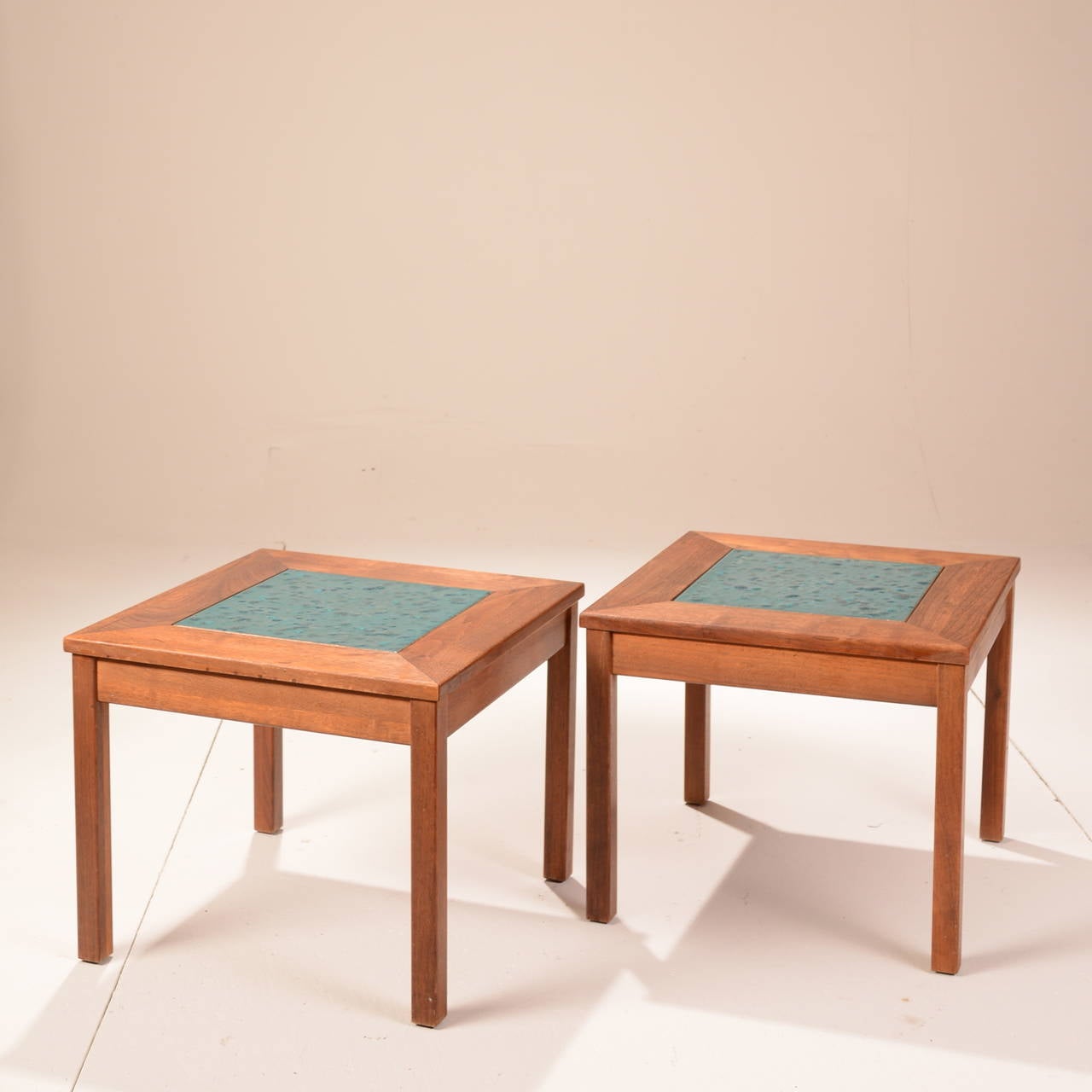 Set of walnut with enamel copper tile tables titled ‘Constellation’ produced by high-end Californian furniture manufacturer, Brown Saltman. These two solid walnut wood tables each feature a unique copper enamel tile inlay in excellent condition.