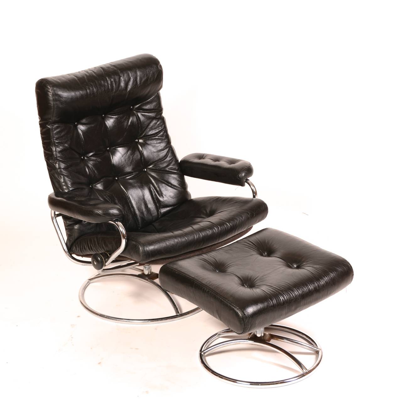 Very comfortable black tufted leather and chrome base Stressless recliner by Ekornes in great vintage condition. A revolution in comfort and functionality,  chair swivels 360 degrees, reclines, and locks in position.