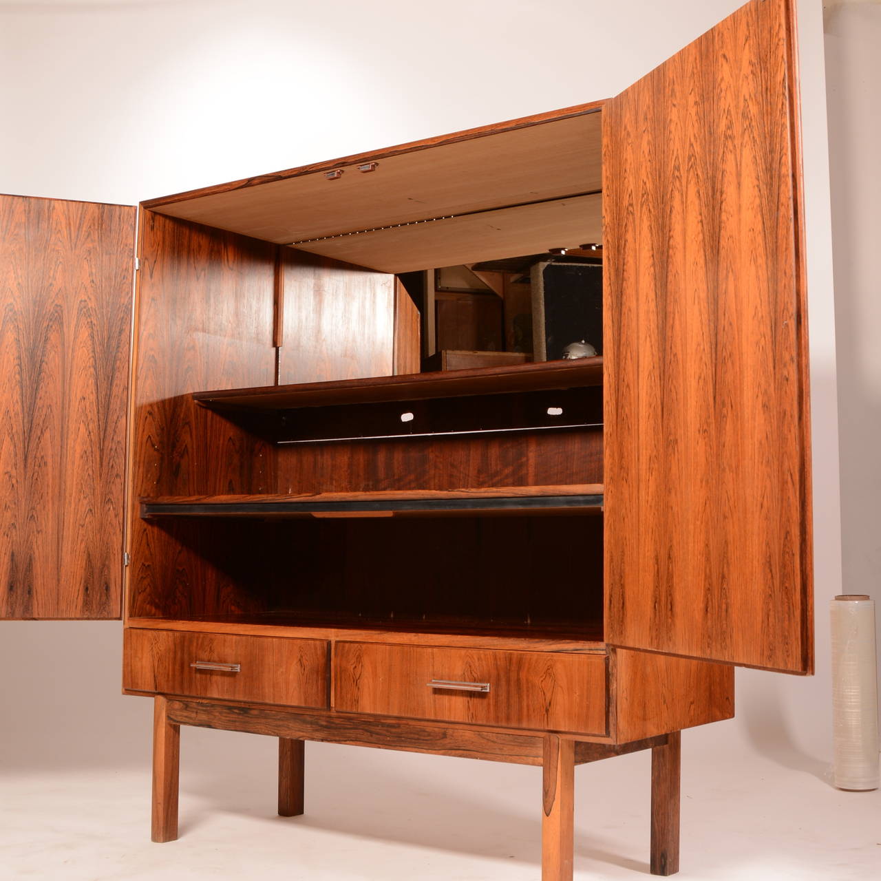 This mid century Danish modern rosewood bar cabinet is in good vintage condition. It includes 2 storage drawers, a pull out serving platform (not shown), one adjustable shelf, one fixed shelf, and back mirror.

53.5”H  47”L  18”D

Local pick up