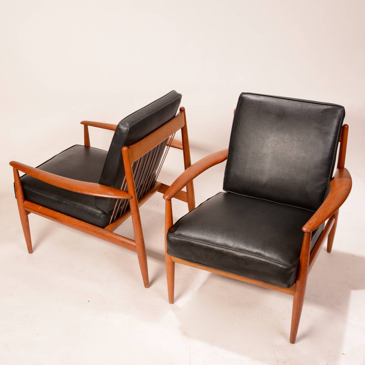 These are early and rare lounge chairs designed by Grete Jalk.  The set includes original black spring cushions.  