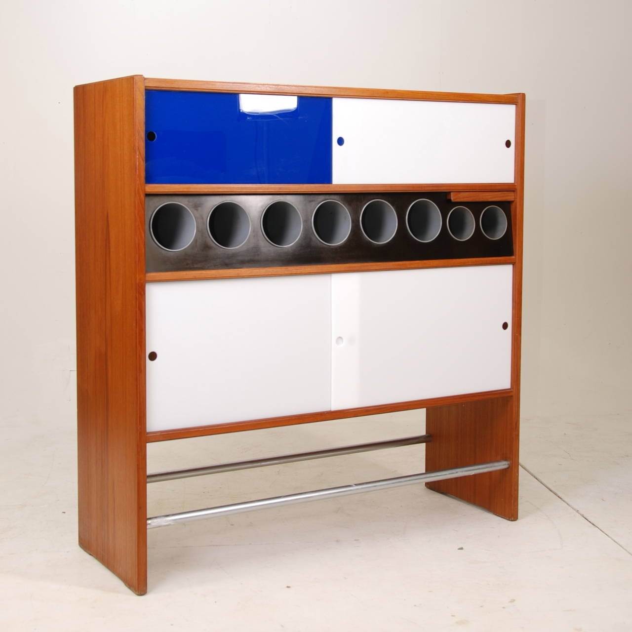 Heltborg Mobler Danish teak bar designed by Poul Heltborg . The bar has 8 bottle holders through the middle and two pull-out stainless steel ice bowls on the right as well as shelving for glassware, a pull out small shelf and acrylic doors. Doors