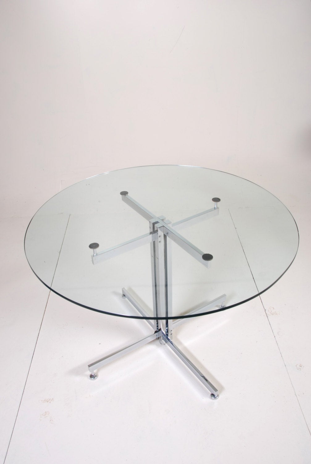 This is a 1960 Hugh Acton designed and built solid steel bar beautifully chromed and polished with a heavy glass top. This chrome and glass top table are in good vintage condition with light wear.