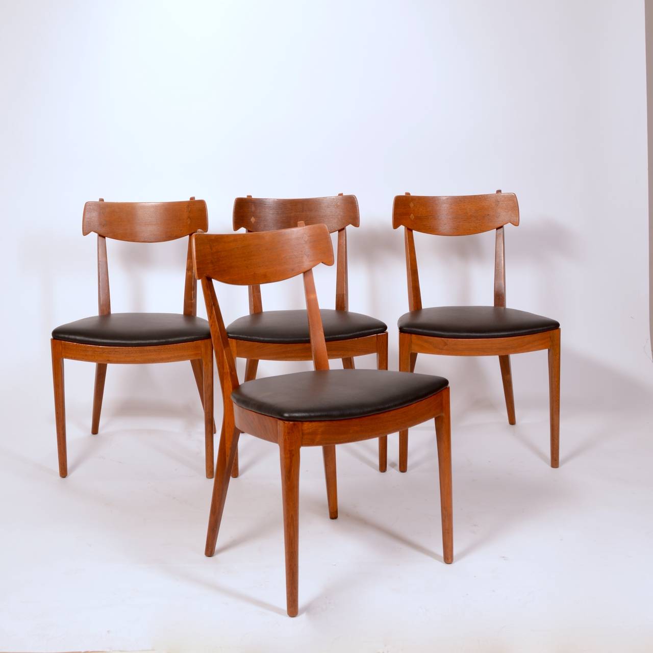 Finely sculpted walnut and rosewood inlayed dining chairs designed by Kipp Stewart and Stuart MacDougall for Drexel, circa 1950.  Newly upholstered