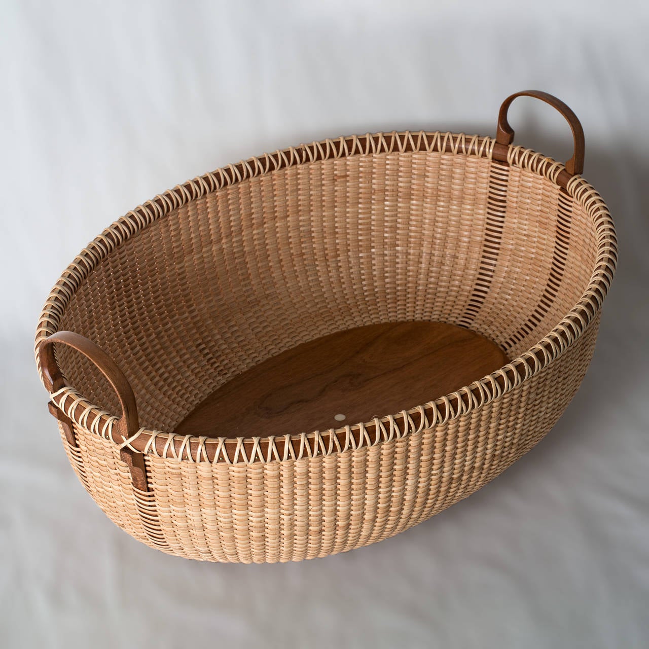 Nantucket basket serving tray by Lucille LaRochelle with carved cherry side handles highlighted by matching cherry staves, cherry rim and base, and rattan woven body