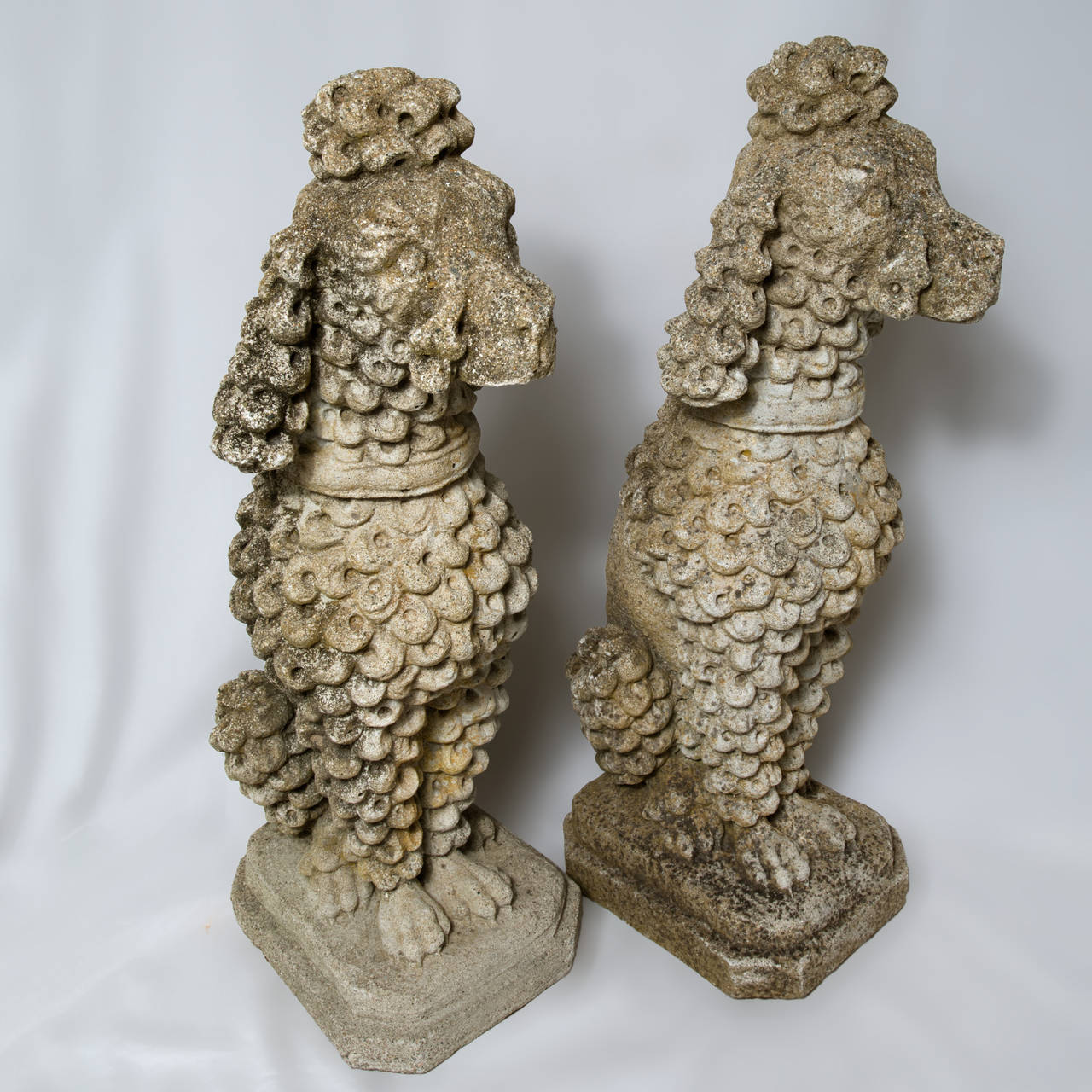 Vintage pair of whimsical entryway composition stone poodles with a great stylized form and weathered surface