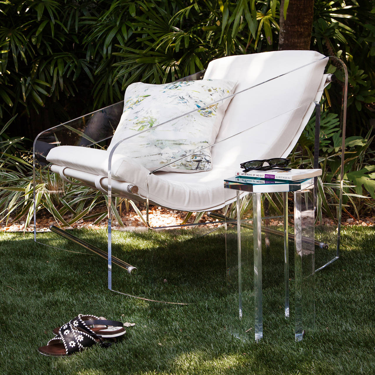 A new take on front porch pastime and relaxation. A polymer mesh sling supports an upholstered cushion that levitates between one inch acrylic panels with wide-curved bases for a floating-effect in both movement and aesthetic. Its uniquely suspended