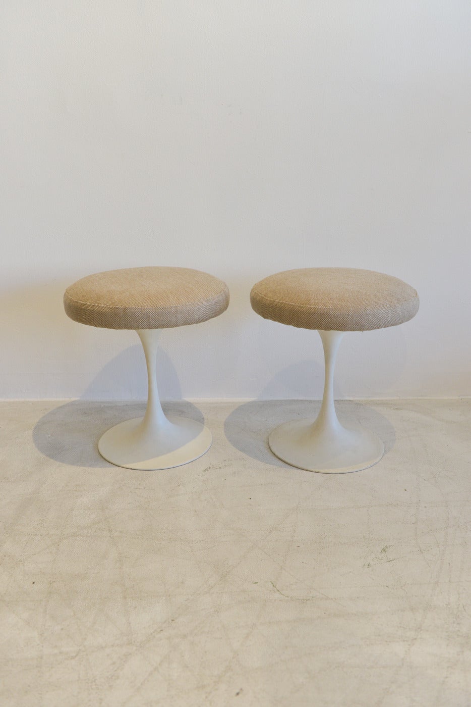 Beautiful pair of Eero Saarinen style tulip base stools made by Burke in the 50's.  Early Arkana base, stamped on underside and fully restored with new foam and neutral beige upholstery.  Easy to match almost anything in your home, these beautiful