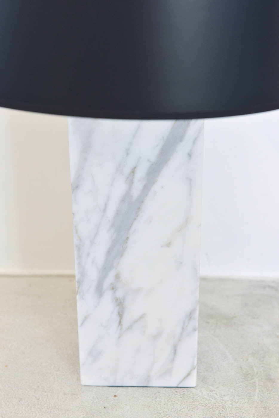 A stunning and extremely heavy and solid marble column table lamp in the style of Robert Sonneman, Nessen Studios or Robsjohn-Gibbings. This solid lamp has beautiful white carrera marble with lovely graining throughout and has a custom made black