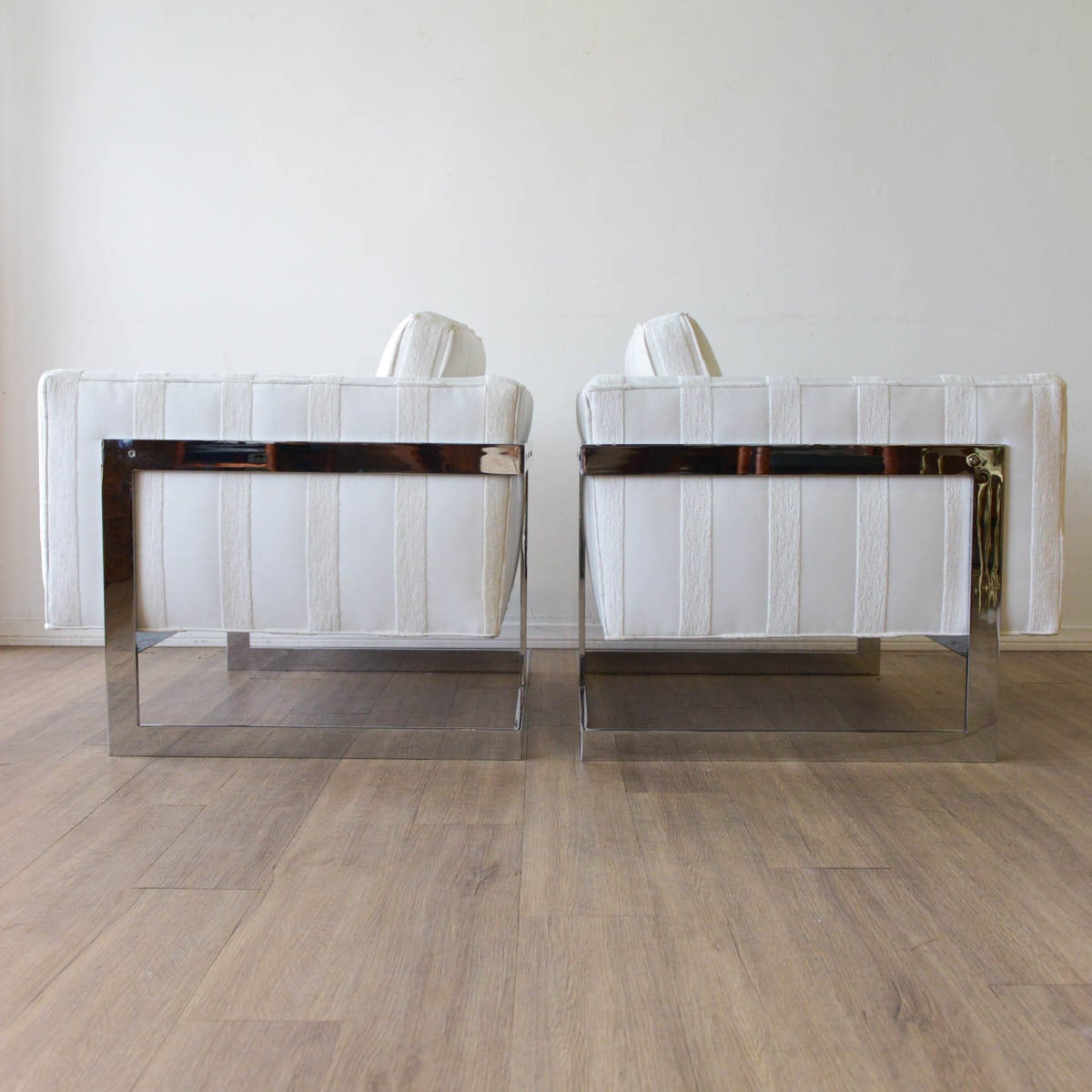 A pair of architectural club chairs in new white textured upholstery and re-plated chrome base. By Milo Baughman for Thayer Coggin, American, circa 1970.

Beautiful floating cube chair design, these are the larger of the two that were made by