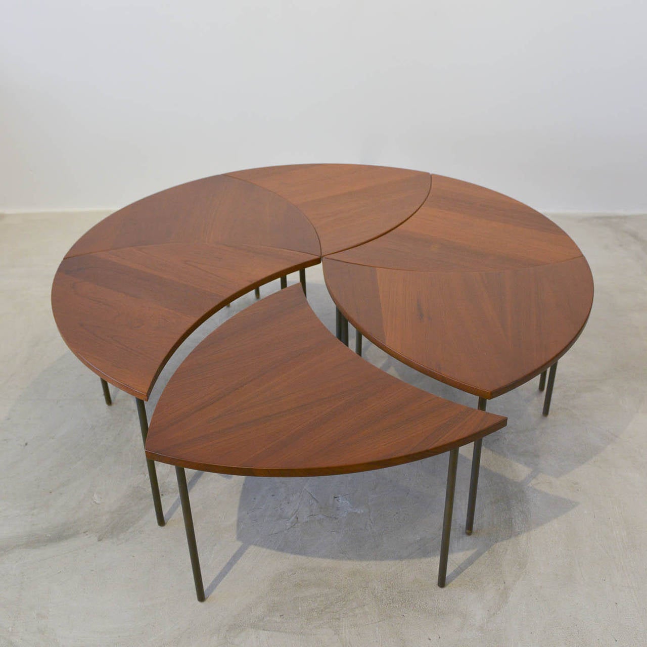 Rare and beautiful segmented teak coffee table by Peter Hvidt for John Stuart. Six identical tables, each with a triangular shape and three legs, can be configured to almost any shape you like, as seen in the photos. Professionally restored to