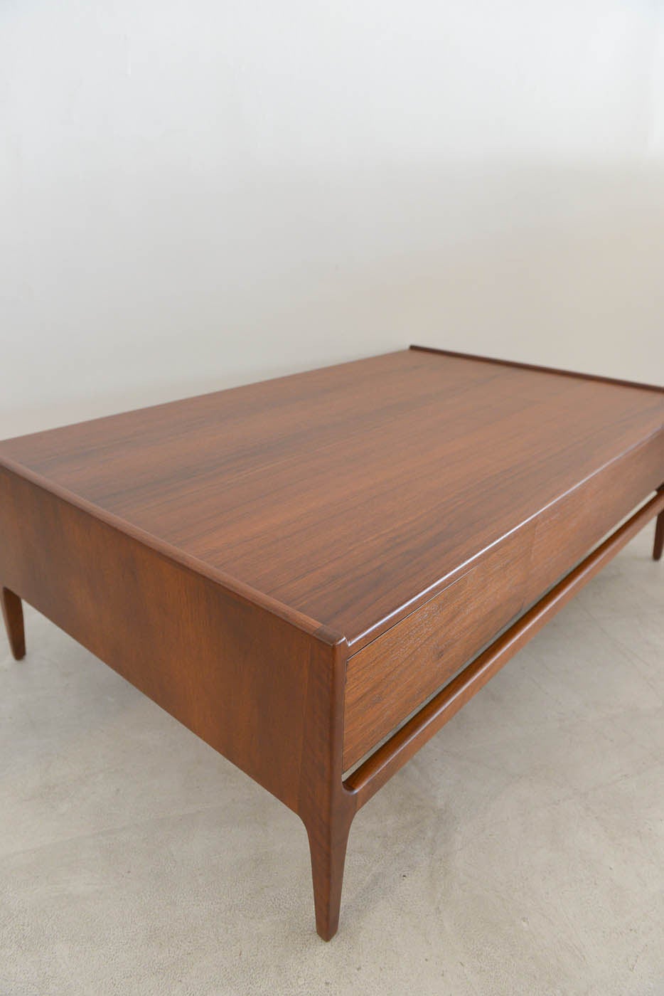 Classic walnut coffee table with hidden sliding drawer that is accessible from either side, this beautiful walnut piece is a classic of Richard Thompson made for Glenn of California. Exceptional walnut and quality throughout, this is a gorgeous