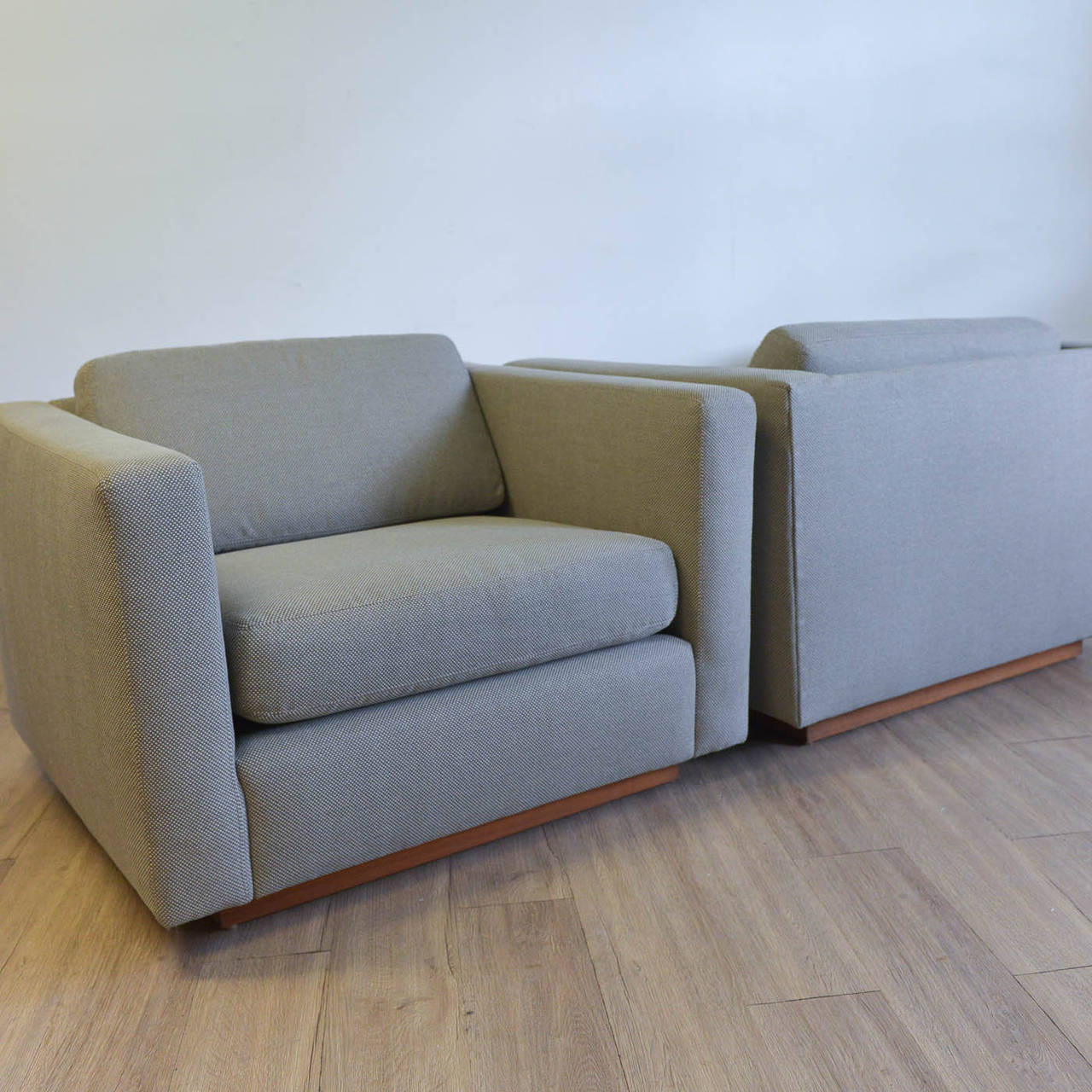 A beautiful pair of original Harvey Probber Cube club chairs. Extremely heavy, well built chairs are on walnut plinth bases and recovered with a very nice grey/beige textured fabric. All new foam and cushions have been added and these chairs are