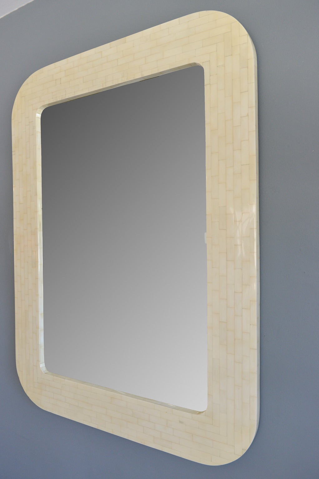 Large rectangular tessellated bone mirror attributed to Karl Springer.  Beautiful condition with no chips in the bone and the mirror is very high quality with no rippling or cracking. Substantial piece, very heavy with curbed edges and pre-installed