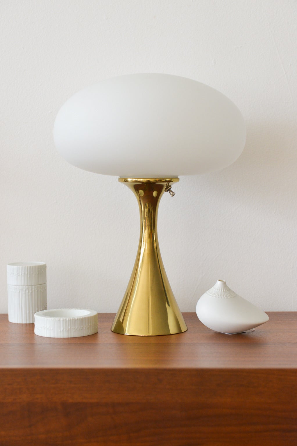 Beautiful brass laurel mushroom lamp in excellent vintage condition by Bill Curry. Shiny brass base with opaque mushroom shade. Emits lovely soft light and looks great on a nightstand, side table or even a wall unit.

Measures 16″ H x 12″ Diameter