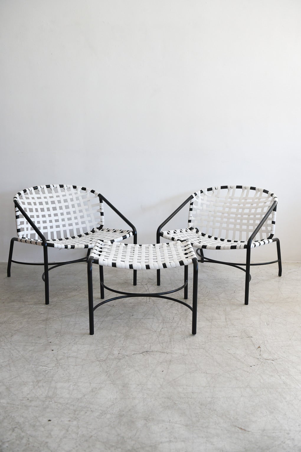 Vintage pair of Tadao Inouye for Brown Jordan Kantan lounge chairs and ottoman. Fully restored with new black powder coat on the frame and contrasting white strapping. Great black and white monochromatic look, these chairs are the lower and wider