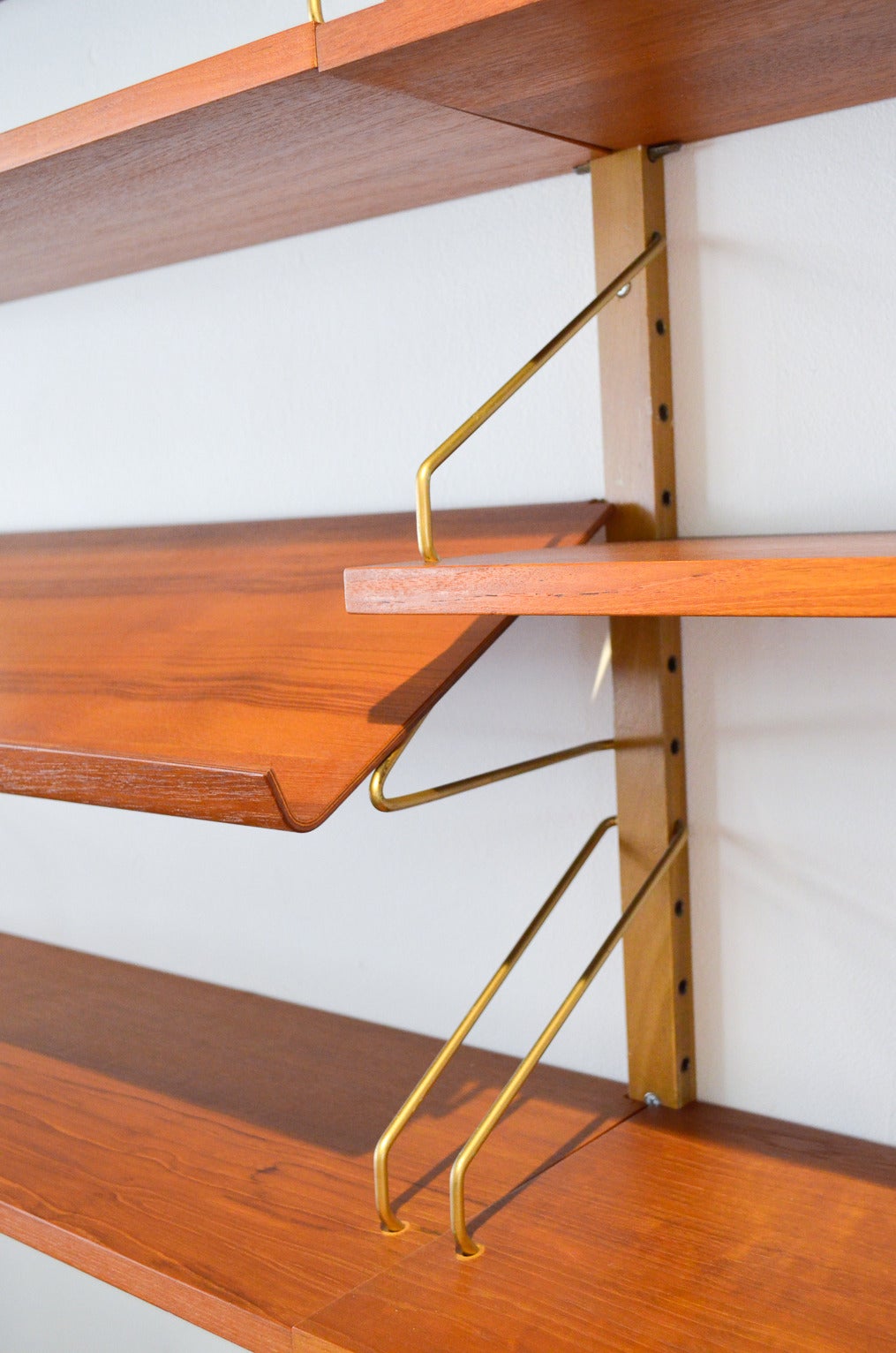 Original Danish modern Cado Royale teak shelving unit designed by Poul Cadovious. Fully modular and adjustable shelving, includes a rare magazine shelf. Excellent vintage condition, this piece easily attaches to any wall with just a few drywall